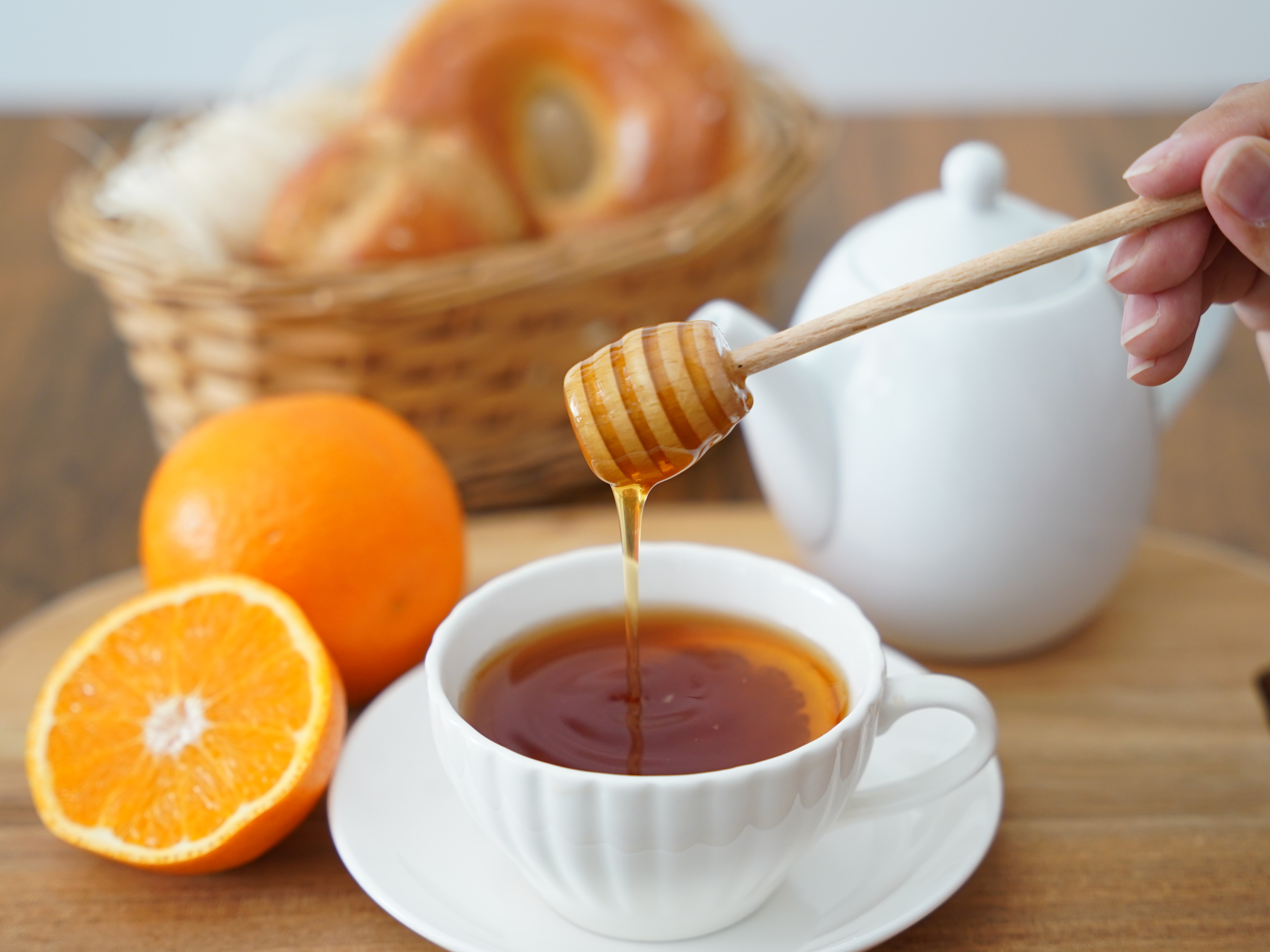 紅茶に蜂蜜を注ぐ、オレンジを添えたティータイム